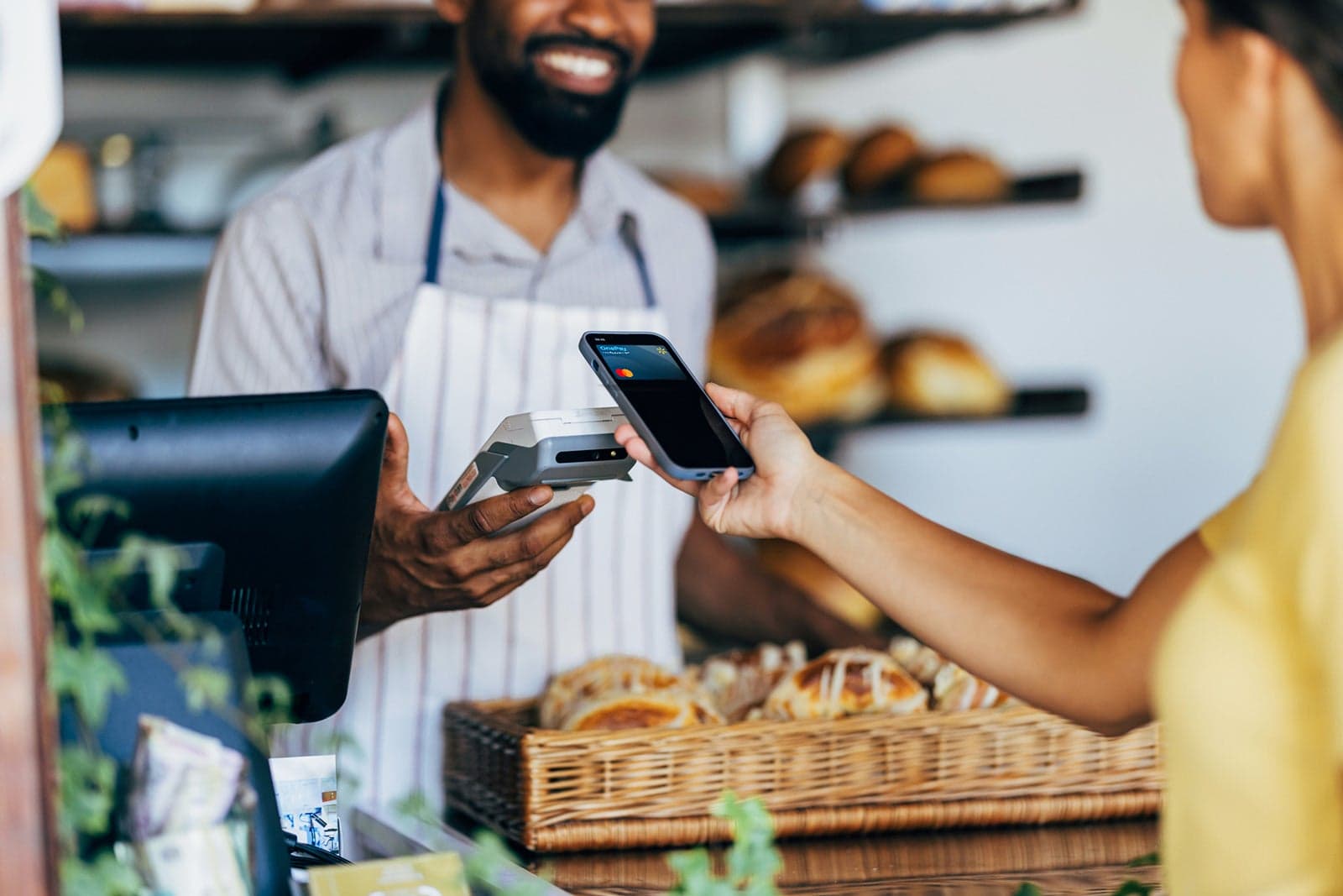 Ein Bäcker nimmt eine mobile Zahlung mit einem Pay2Easy Terminal an