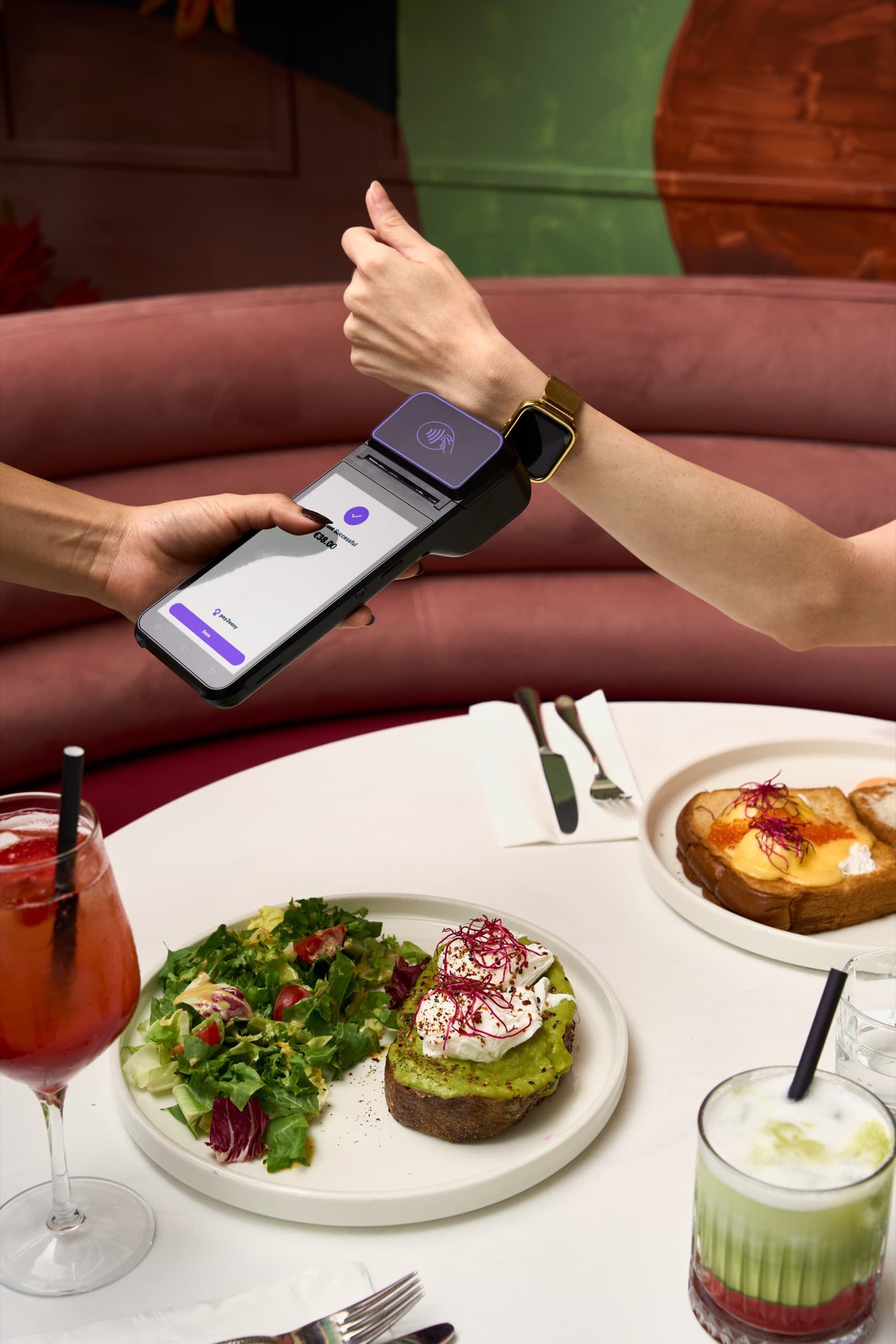 A vendor holding an iPhone showing a Tap to Pay charge next to a customer's contactless card