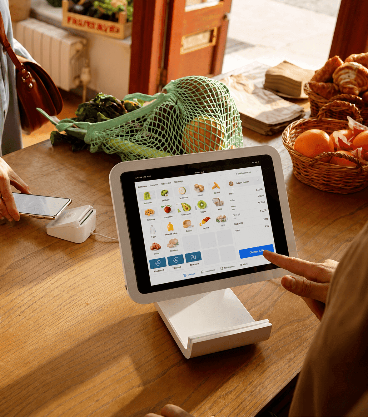 Shopper paying at a Pay2Easy POS tablet on a market counter